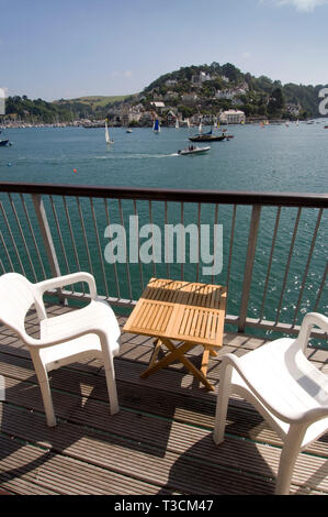 Ein Paar (männlich & weiblich), genießen Sie die Aussicht über den Fluss Dart Flussmündung zu Kingswear vom Balkon Ihres Hauses in Dartmouth, Devonshire, Großbritannien Stockfoto