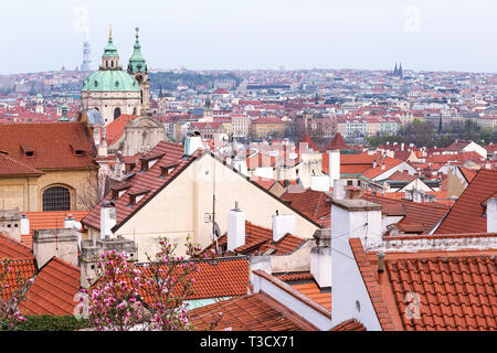 Feder Luftaufnahme auf Häusern und alten roten Dächer der Prager Altstadt Stadt einschließlich der St. Nikolaus Kirche. Blühende Bäume im Vordergrund. Der Tschechischen Republik Stockfoto