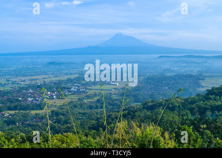 Yogyakarta Becken und Merapi Volcano droht in die Ferne. Merapi ist ein sehr aktiver Vulkan Stockfoto