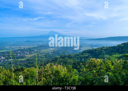 Yogyakarta Becken und Merapi Volcano droht in die Ferne. Merapi ist ein sehr aktiver Vulkan Stockfoto