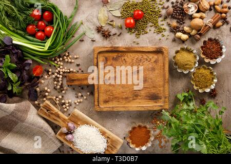 Frischem Gemüse und Tomaten Gewürze Getreide und Nüsse Bio gesunde Snacks auf einer strukturellen Hintergrund. Konzept der gesunden Ernährung. Rahmen unter dem Text. Stockfoto