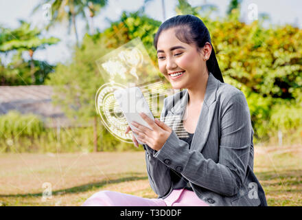 Schöne asiatische Geschäftsfrau mit digitalen Tablet auf ihre Hand mit virtuellen Bildschirm, der die Schnittstelle der Weltkarte und binären Code auf der Pa-Anzeige Stockfoto