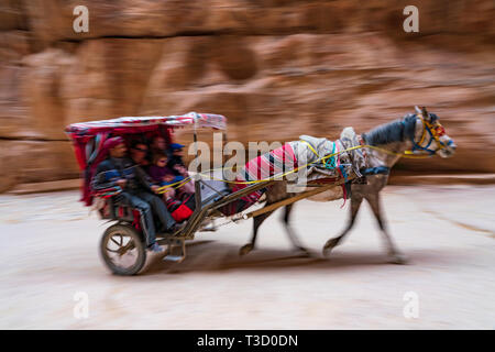 Eine Kutschenfahrt mit Touristen in der siq Schlucht zum Haupteingang des antiken nabatäische Stadt Petra, Jordanien. Stockfoto