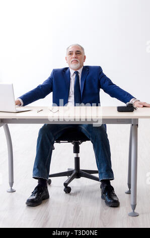 Alter Geschäftsmann Yoga Übungen im Büro Stockfoto