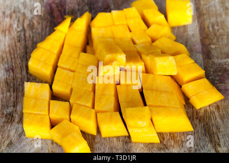 Schneiden Sie in kubischer Teile von Reifen gelben Kürbis Zellstoff, beim Kochen in der Küche Stockfoto