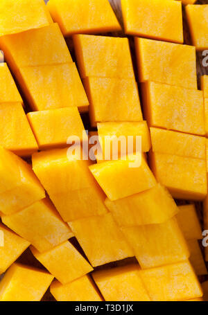 Schneiden Sie in kubischer Teile von Reifen gelben Kürbis Zellstoff, beim Kochen in der Küche Stockfoto