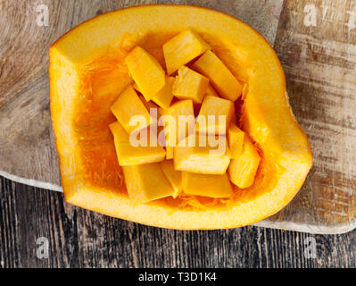 Schneiden Sie in kubischer Teile von Reifen gelben Kürbis Zellstoff, beim Kochen in der Küche liegt in den Rest der Kürbis Stockfoto