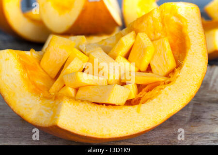 Schneiden Sie in kubischer Teile von Reifen gelben Kürbis Zellstoff, beim Kochen in der Küche liegt in den Rest der Kürbis Stockfoto