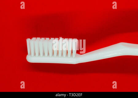 Profil anzeigen von White Zahnbürste auf rotem Hintergrund Stockfoto