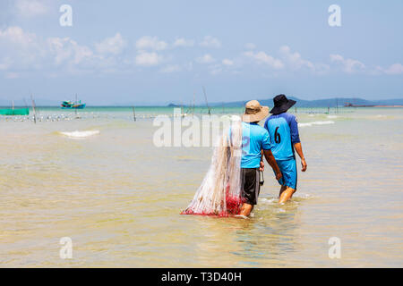 Lokale vietnamesische Fischer zu Fuß durch das Wasser an die Bai Dai Tay Strand, auf der Insel Phu Quoc im Golf von Thailand, Vietnam, Asien, Stockfoto