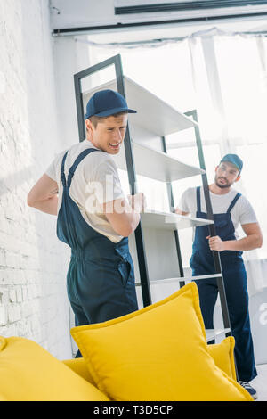 Zwei movers in Uniform Transport Rack in der Wohnung Stockfoto