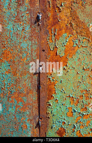 Textur des alten rostigen Metall, lackiert in Blau und Grün, Orange wird von Rost. Die vertikale Struktur der Risse im Lack auf rostigen geschweißte Bleche Stockfoto