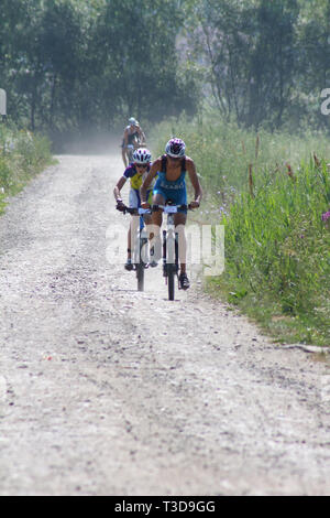 Gruppe von triathlonists Anfahren auf Mountainbikes während der Konkurrenz Stockfoto