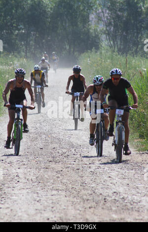 Gruppe von triathlonists Anfahren auf Mountainbikes während der Konkurrenz Stockfoto