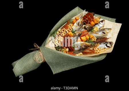Geschenk für einen echten Mann in Form einer Bukett von getrockneten Fisch und verschiedenen Snacks auf schwarzem Hintergrund Stockfoto