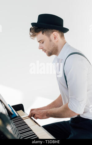 Konzentriert Pianist in stilvolle Kleidung Klavier spielen Stockfoto