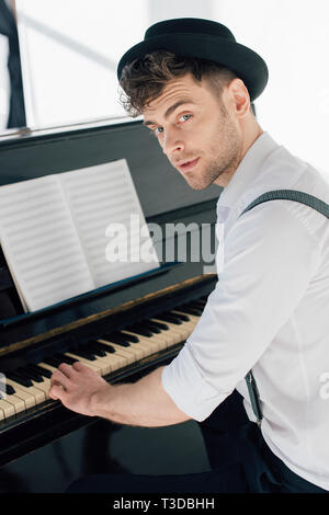 Stattliche Pianist in stilvolle Kleidung Klavier spielen zu Hause Stockfoto