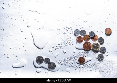 Britische Währung in den Wassertropfen auf einem weißen Hintergrund. - Bild Stockfoto