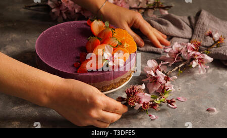 Raw vegan Kuchen mit Früchten und Samen, mit Blumen dekoriert Stockfoto
