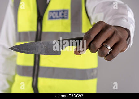 Salisbury, Wiltshire, UK. April 2019. Polizei Offizier, der Inhaber eines festgelaufen Küchenmesser Stockfoto