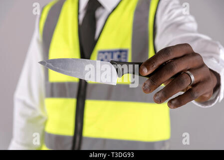 Salisbury, Wiltshire, UK. April 2019. Polizei Offizier, der Inhaber eines festgelaufen Küchenmesser Stockfoto