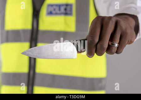 Salisbury, Wiltshire, UK. April 2019. Polizei Offizier, der Inhaber eines festgelaufen Küchenmesser Stockfoto