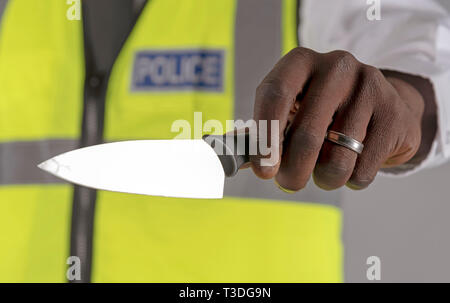 Salisbury, Wiltshire, UK. April 2019. Polizei Offizier, der Inhaber eines festgelaufen Küchenmesser Stockfoto