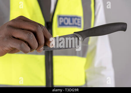 Salisbury, Wiltshire, UK. April 2019. Polizei Offizier, der Inhaber eines festgelaufen Küchenmesser Stockfoto