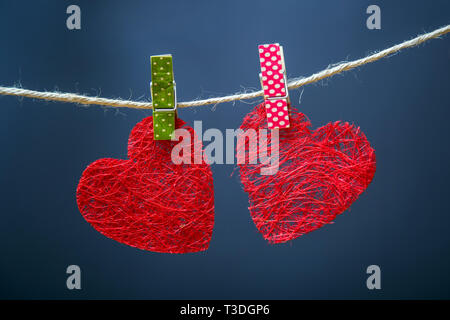 Symbole der Liebe. Herzen aus Sisal Stoff. Es trocknet auf einem Seil. Handgefertigt. Karte für den Valentinstag. Stockfoto