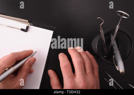 Zahnarzt Arzt schreiben auf seinem Schreibtisch. Ansicht von oben. Horizontale Komposition. Stockfoto