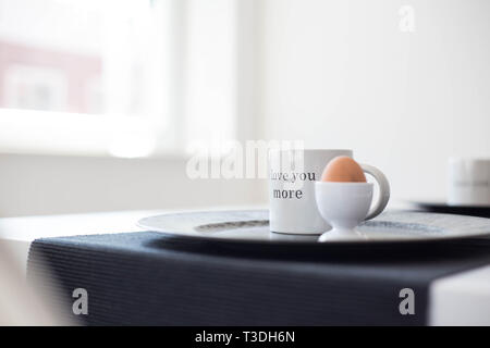 Leckeres und gesundes Frühstück mit einem gekochte Eier und eine Kaffeetasse auf einem weißen Hintergrund, mit dem Text "Ich liebe Dich mehr close-up Stockfoto