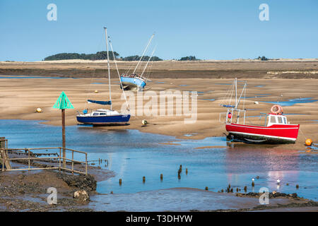 Bunte Boote marooned auf Sandbänken bei Ebbe im Osten Flotte Mündung an der Brunnen neben dem Meer, North Norfolk Coast, East Anglia, England, UK. Stockfoto