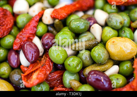 Oliven, Cornichons, Knoblauch, Chili und geröstete Paprika Antipasti mit Olivenöl gemischt Stockfoto