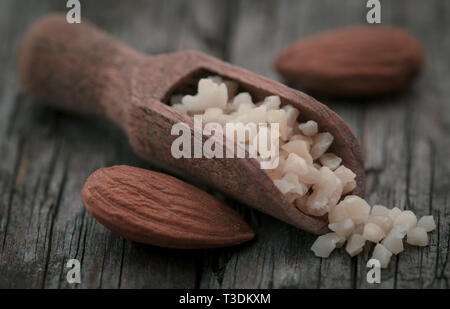 Kleine Stücke gehackten Mandeln in Holz- Schaufel mit ganzen, Stockfoto