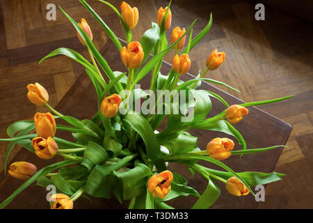 Overhead shot von einem Blumenstrauß orange Tulpen über einen rustikalen, mit Holz Tisch. Flach Draufsicht Stil. Stockfoto