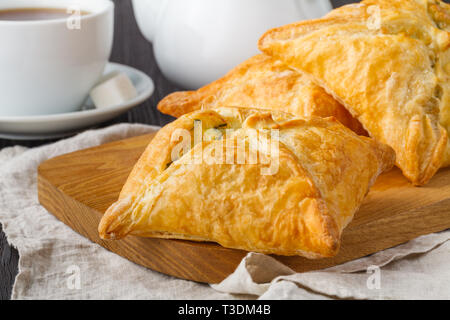 Blätterteig Dreiecke mit Schafskäse und Spinat auf hölzernen Tisch gefüllt Stockfoto