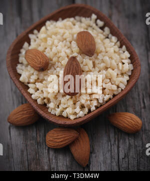 Kleine Stücke gehackten Mandeln mit ganzen, in eine Schüssel geben. Stockfoto