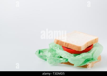 In Einzelnutzung Plastiktüten und Kunststoff sich wieder verwendbare Einkaufstaschen auf einer hölzernen Oberfläche in der Natur produzieren. Null Abfall Lebensstil Stockfoto