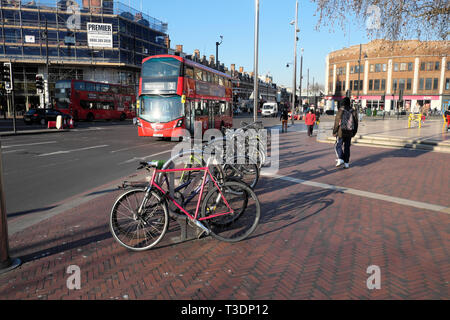 Doppeldecker roter Bus, Fußgänger, geparkte Fahrräder im Fahrradstand Straßenansicht der Straße auf Brixton Hill in Brixton South London England Großbritannien KATHY DEWITT Stockfoto