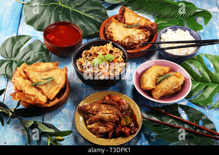 Verschiedene chinesische Gerichte. Chinesische Nudeln, gebratener Reis, Pekingente, Dim Sum, Frühlingsrollen. Berühmte chinesische Gerichte auf den Tisch. Chinesisches Restaurant Stockfoto