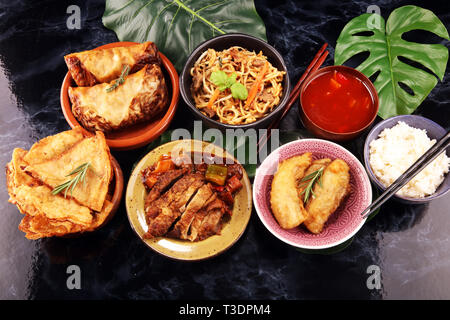 Verschiedene chinesische Gerichte. Chinesische Nudeln, gebratener Reis, Pekingente, Dim Sum, Frühlingsrollen. Berühmte chinesische Gerichte auf den Tisch. Chinesisches Restaurant Stockfoto