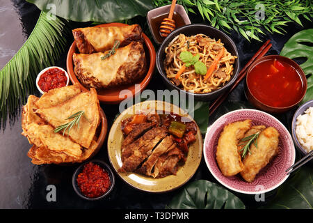 Verschiedene chinesische Gerichte. Chinesische Nudeln, gebratener Reis, Pekingente, Dim Sum, Frühlingsrollen. Berühmte chinesische Gerichte auf den Tisch. Chinesisches Restaurant Stockfoto