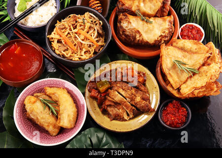 Verschiedene chinesische Gerichte. Chinesische Nudeln, gebratener Reis, Pekingente, Dim Sum, Frühlingsrollen. Berühmte chinesische Gerichte auf den Tisch. Chinesisches Restaurant Stockfoto