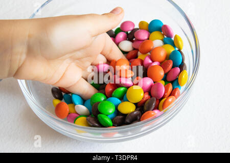 Runde, bunte Süßigkeiten. Candy close-up, in einem Glasbehälter. Das Kind hält Süßigkeit. Stockfoto