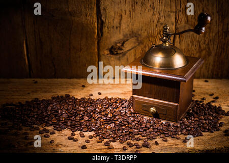 Alte Kaffeemühle mit frisch gerösteten Bohnen auf urigen alten Vintage Retro eiche Hintergrund Stockfoto