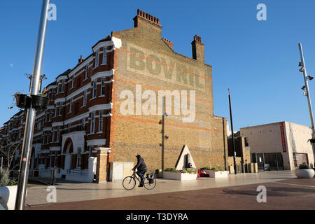 Mann auf dem Fahrrad Radfahrer Radfahren in Windrush Square und dem bovril Gebäude neben Schwarz Kulturzentrum in Brixton South London England UK KATHY DEWITT Stockfoto