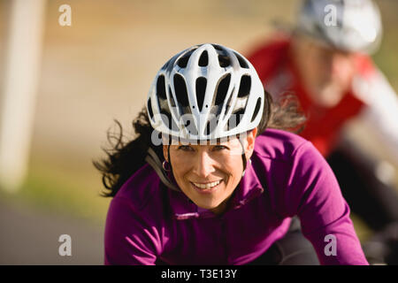 Reife Frau trägt einen Fahrradhelm und lächelnd Stockfoto