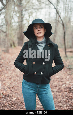 Eine schwarzhaarige Frau genießt eine sonnige Wintertag im Wald Stockfoto