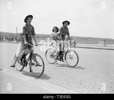 Zwei Pfadfinder geben ihre Freundinnen eine Fahrt mit dem Fahrrad über den Arlington Bridge CA. 1937 Stockfoto