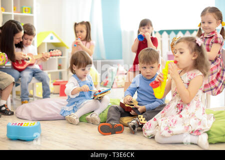 Lehrer und Kinder Gruppe während der musikstunde im Kindergarten Stockfoto